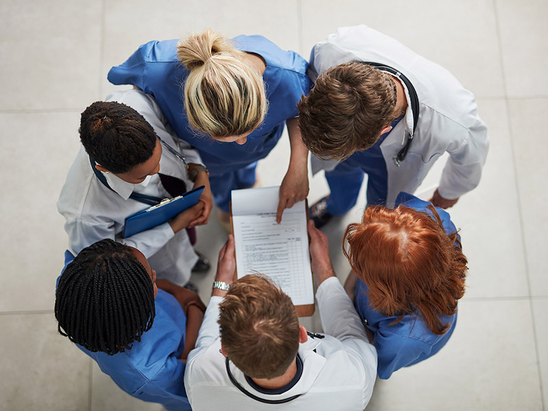 A group of medical professionals looking down at a piece of paper