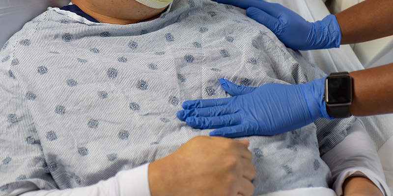 A closeup of a hand on a patients heart