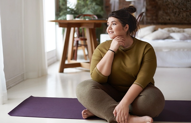 photograph of woman sitting in the living room of her house looking at the horizon