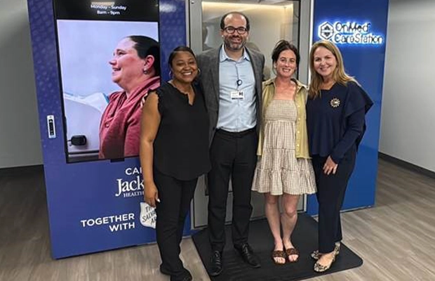 Group of four people posing and smiling at the camera.