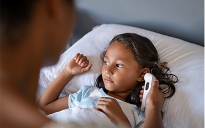 Doctor examining ear of girl
