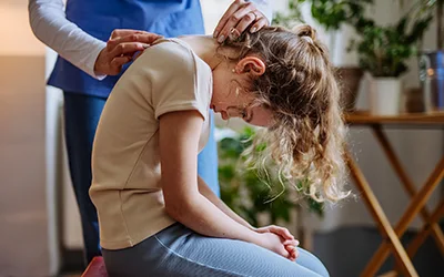 A young girl getting her backed checked by a medical professional