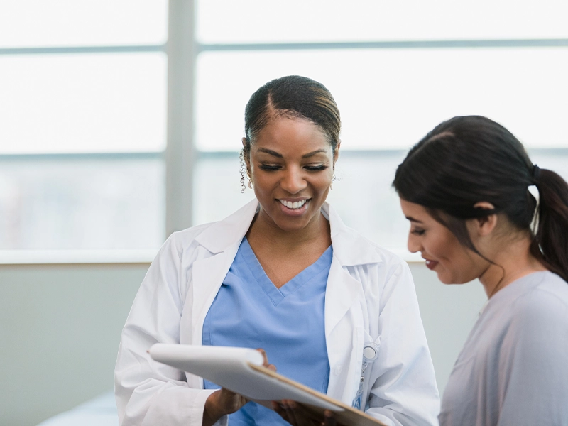 A female doctor speaking with a female patient.