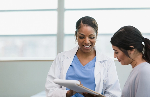 A female doctor speaking with a female patient.