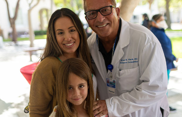 Mother and daughter posing with a doctor