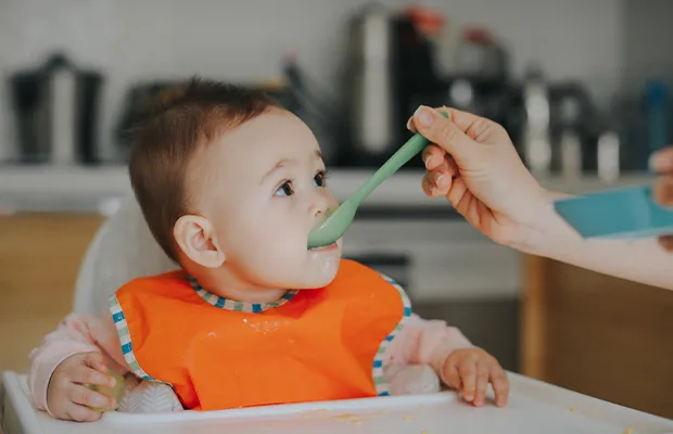 baby in orange t-shirt eating