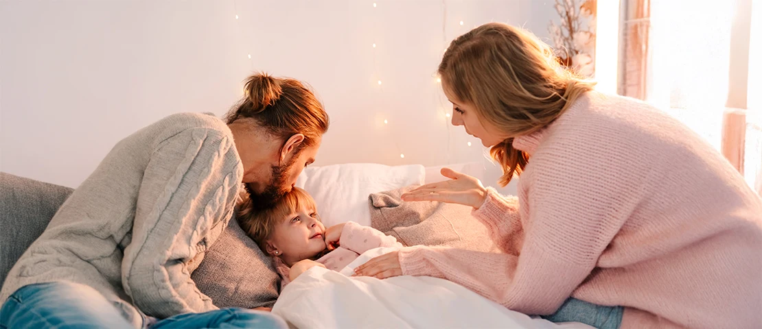 Two parents speaking to their child they are on a couch