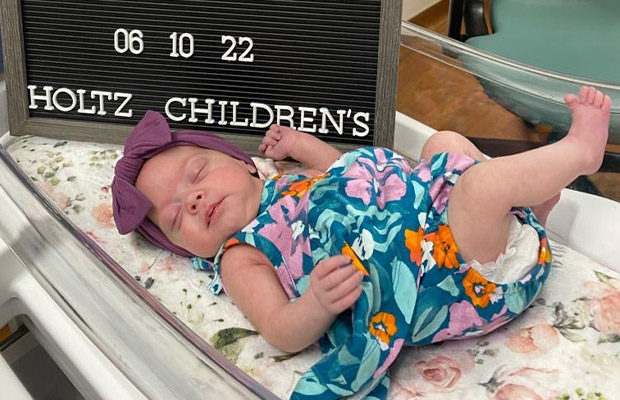 Baby dressed in flower dress sleeping