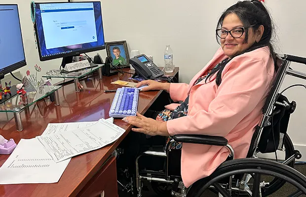 Woman working at her desk, sitting in her wheelchair