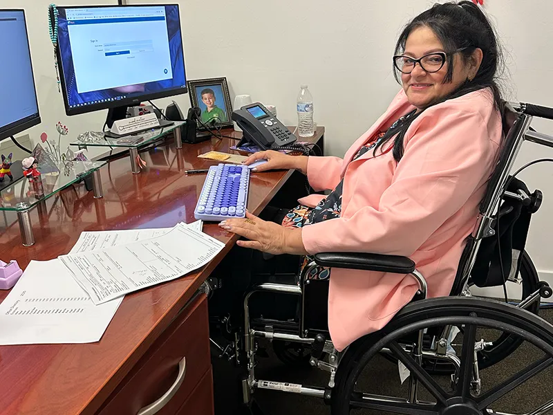 Woman working at her desk, sitting in her wheelchair