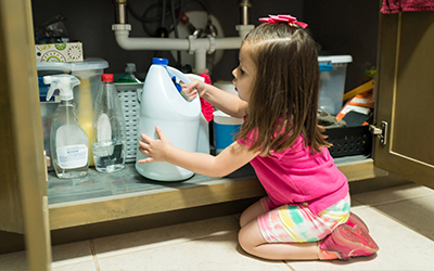 girl manipulating containers of cleaning products