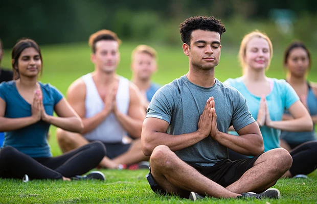 A group of people meditating outdoors