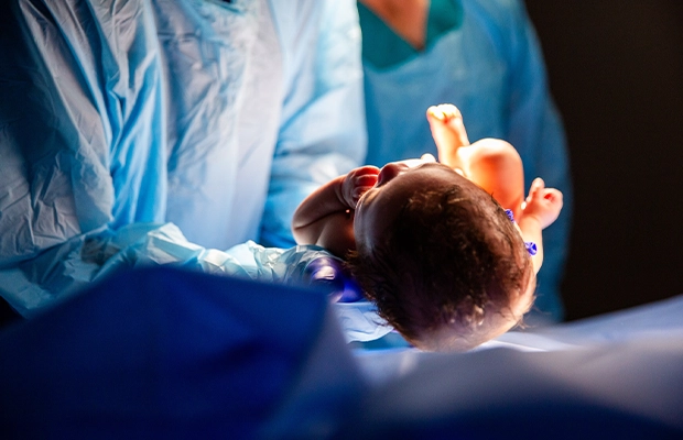 Close-up of a newborn being held by the doctor.