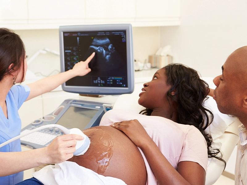 Pregnant woman being examined by a doctor with her partner