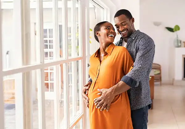 man hugging pregnant woman