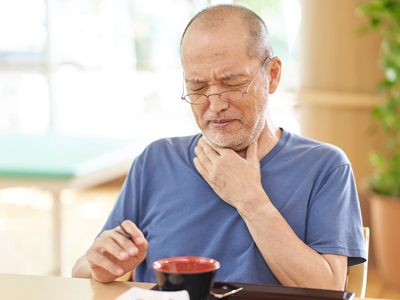 elderly man suffering from throat pain