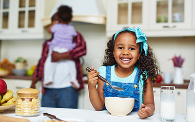 girl smiling while eating something in the kitchen