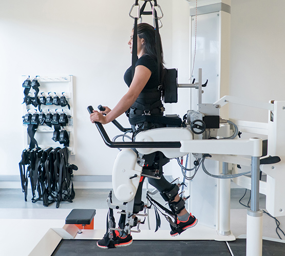 Injured woman doing physical therapy on a robot machine to recover movement on her legs