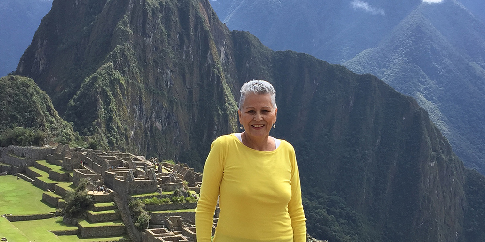 Maty outside smiling in front of a large mountain range