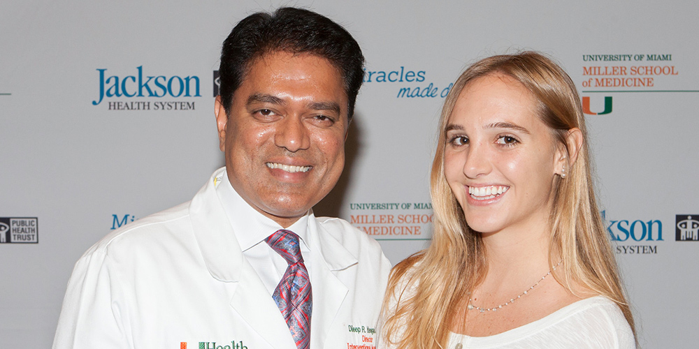 Isabel Vinueza standing next to doctor Yavagal, they are both smiling and standing in front of a step and repeat