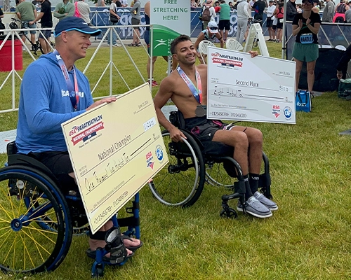 man showing giant chque he won in wheelchair competition