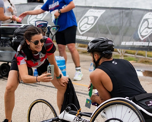woman taking photograph of man in wheelchair