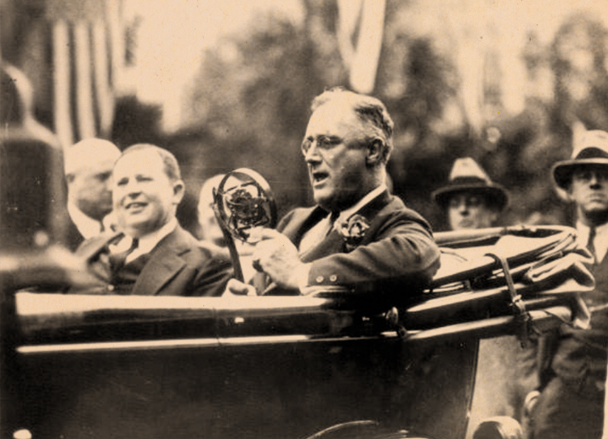 Black and white image of an older gentleman in the back of a car and two men following the car