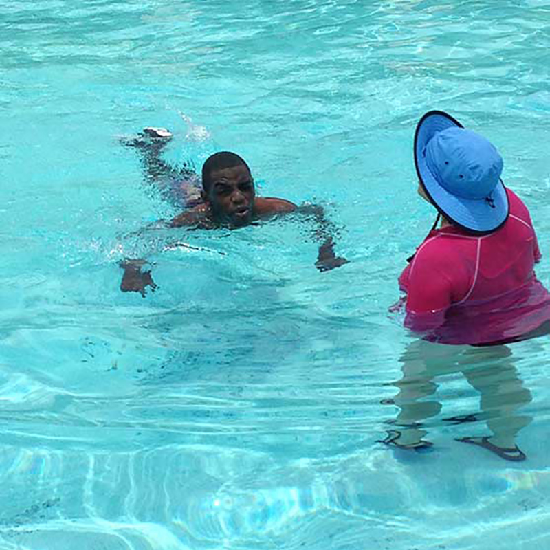 Aaron Willis swimming in a pool next to another person