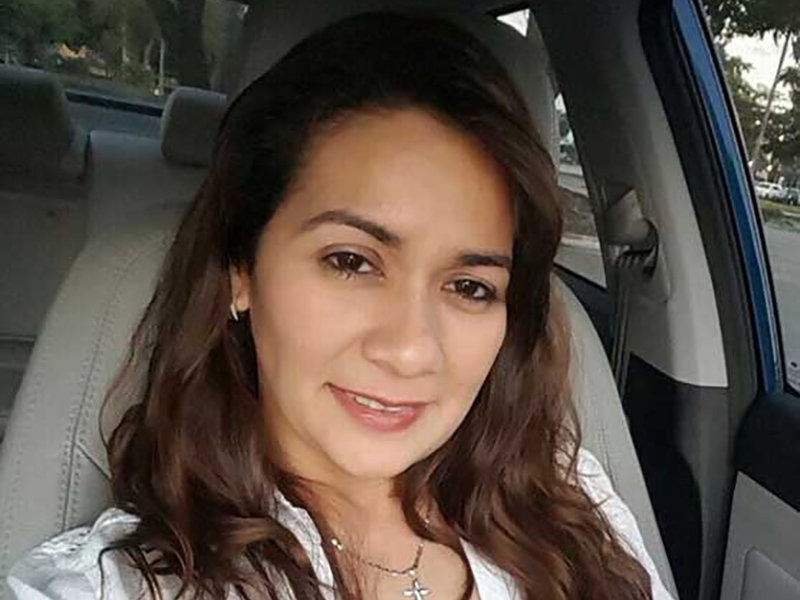 Evelin Matamoros smiling in a car, she's wearing a white shirt