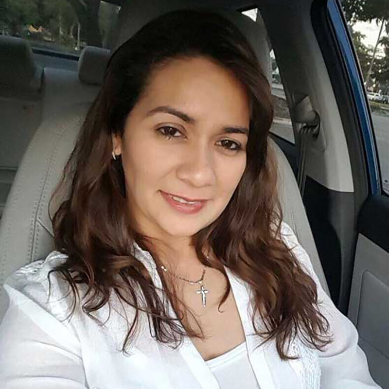 Evelin Matamoros smiling in a car, she's wearing a white shirt