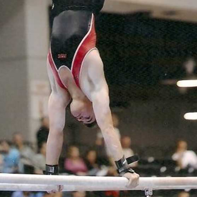 Jorge Valdes doing a hand stand on two polls
