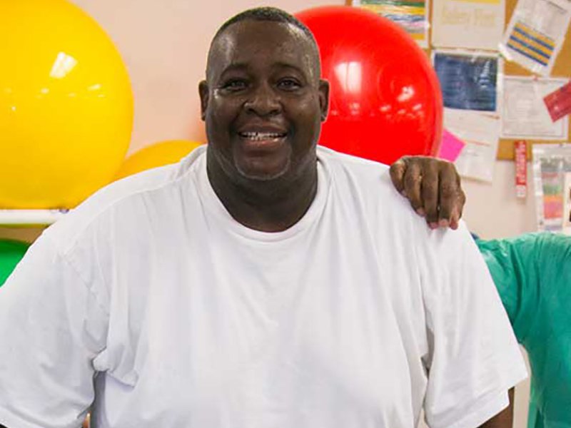 Closeup of Robert Billue during a therapy session, he's smiling and wearing a white shirt