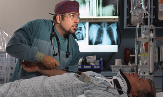 A trauma physician taking care of a patient in a hospital room