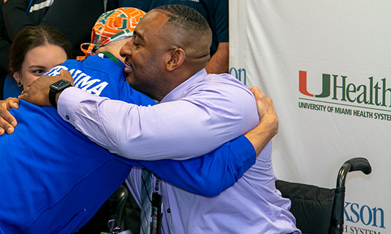 A Ryder patient who is in a wheelchair hugging a Trauma doctor