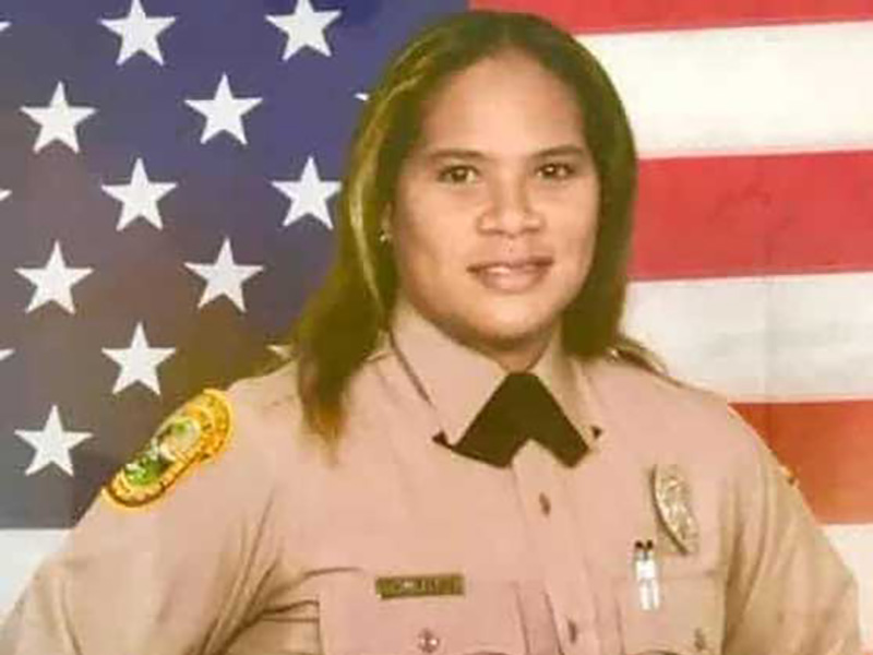 Jody Wright in her police uniform in front of an American flag