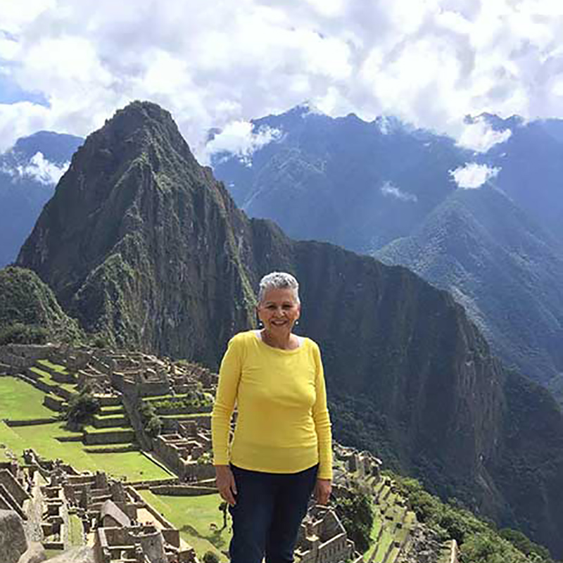 Maty outside smiling in front of a large mountain range