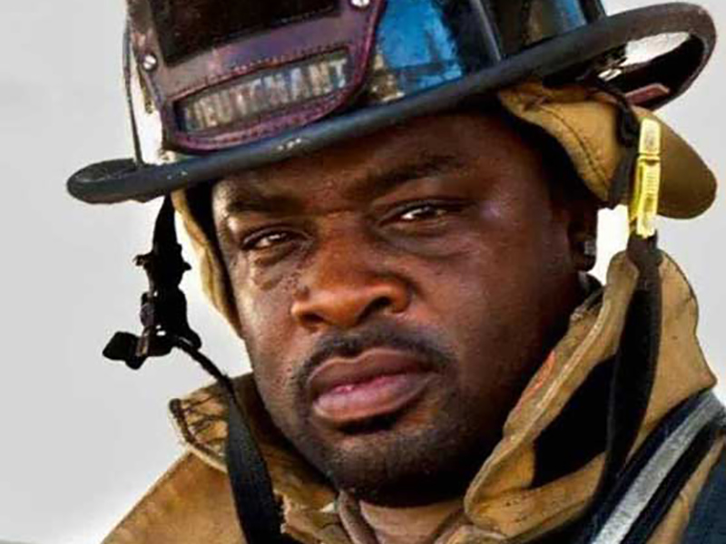 Lieutenant Kevin McCrea wearing a firefighter suit and hat