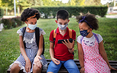 3 children watching the cell phone