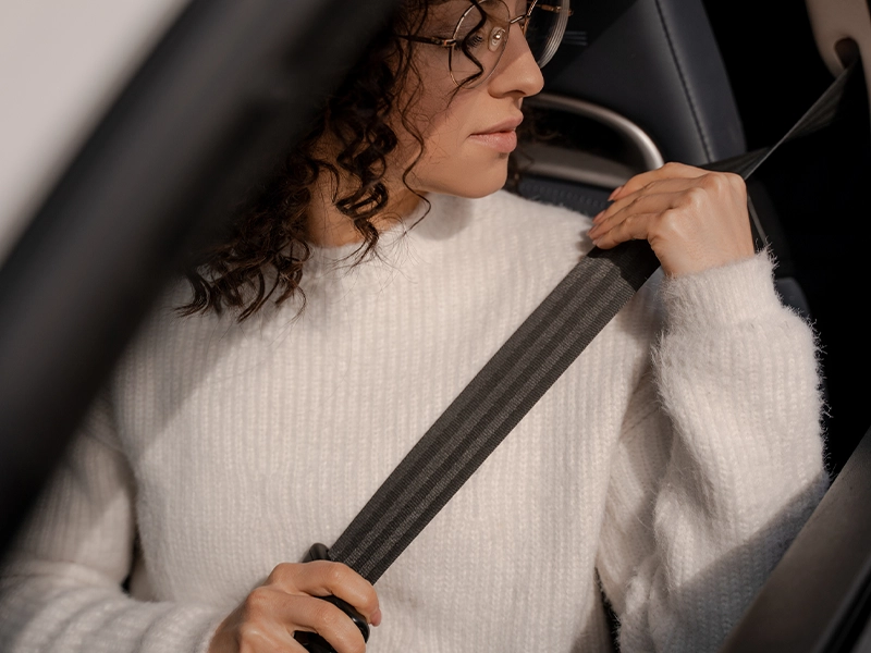Woman correctly using the car seat belt.