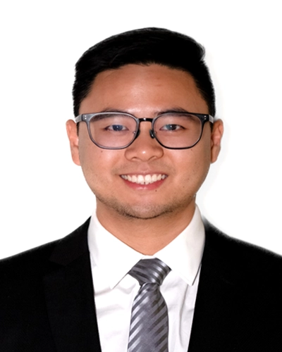 Professional headshot of Shi-Yen, a man smiling, against a gray studio background