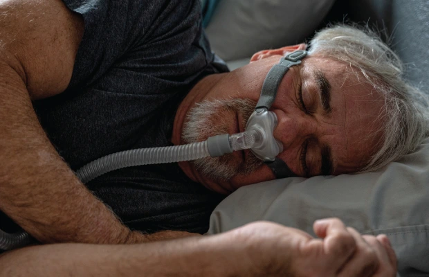 Elderly man sleeping on his side with an oxygen tank attached