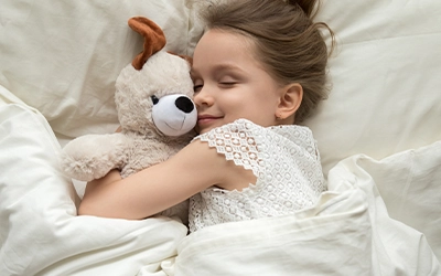 girl sleeping with teddy bear
