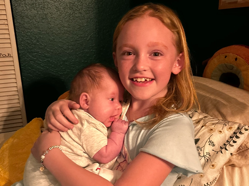 little girl holding a baby