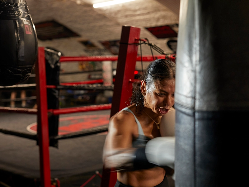Photograph of a woman exercising with a punching bag