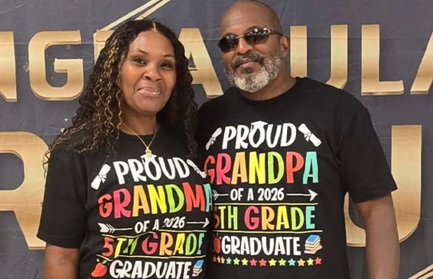 A couple posing for the camera; both are wearing the same black T-shirt with the same print.