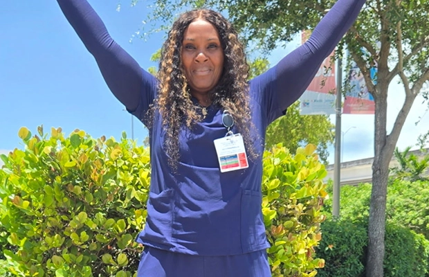 Woman wearing a blue suit raising her arms.
