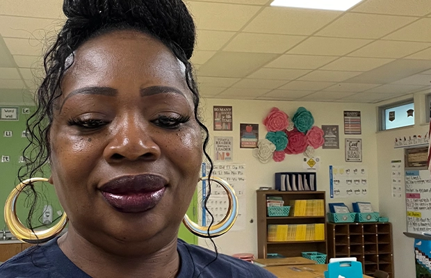 Close-up of woman smiling at camera in school classroom