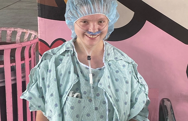 A person wearing a surgical gown and a tube