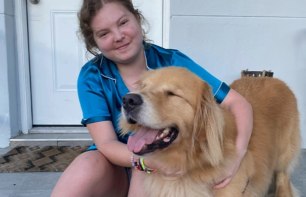 A child sitting on a porch with a dog