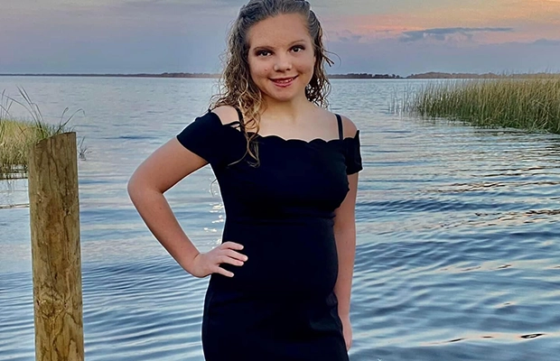 A person in a black dress standing in water